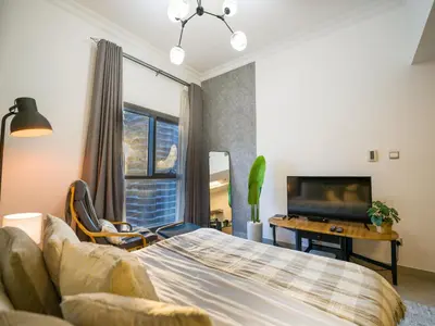 a bedroom with a bed and a desk and a tv at EasyGo- Comfy STU in Dubai Marina -Zum04 in Dubai
