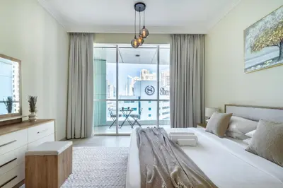 a bedroom with a bed and a large window at Classic Retreat in JBR with Private Beach Access in Dubai