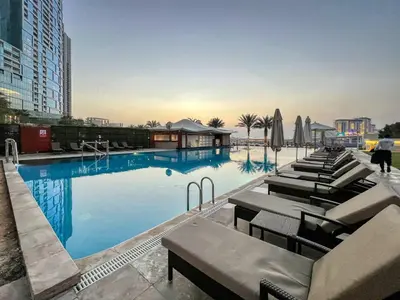 a large swimming pool with lounge chairs and umbrellas at Classic Retreat in JBR with Private Beach Access in Dubai
