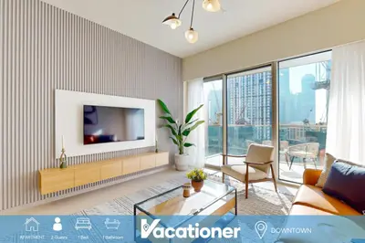 a living room with a television on a wall at Grande Residence - Contemporary One Bedroom in Dubai