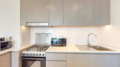 a kitchen with a sink and a stove top oven at Grande Residence - Contemporary One Bedroom in Dubai