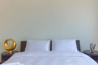 a bed with white sheets and white pillows at Private Pool & Direct Beach Access-4BDR Villa in Dubai