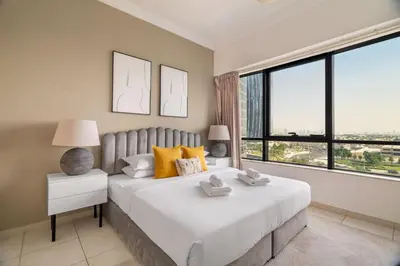a bedroom with a large bed and a large window at GuestReady - Modern retreat in JLT in Dubai