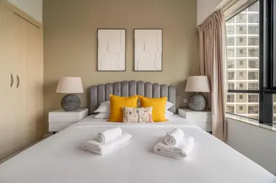 a bedroom with a large white bed with yellow pillows at GuestReady - Modern retreat in JLT in Dubai