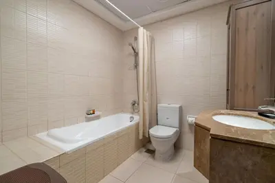a bathroom with a tub and a toilet and a sink at GuestReady - Modern retreat in JLT in Dubai