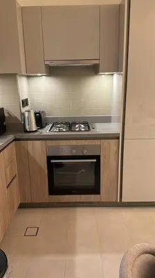 a kitchen with a stove and a refrigerator at Luxury apartment in Sobha Hartland Waves near Dubai mall and Burj Khalifa in Dubai