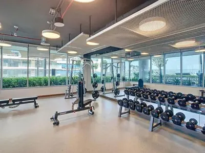 a gym with a lot of equipment and windows at Pure Voyage Beachfront in Dubai