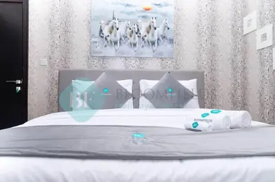 a white bed with pillows and towels on it at Bloomfields Cozy 1br In Silicon Oasis in Dubai
