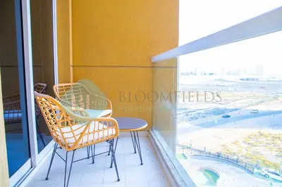 a balcony with two chairs and a table and a window at Bloomfields Cozy 1br In Silicon Oasis in Dubai