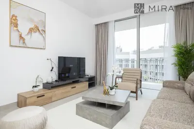 a living room with a couch and a tv at Mira Holiday Homes - Luxury and cosy 1 bedroom in JVC in Dubai