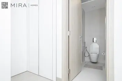 a bathroom with a toilet in a white room at Mira Holiday Homes - Luxury and cosy 1 bedroom in JVC in Dubai
