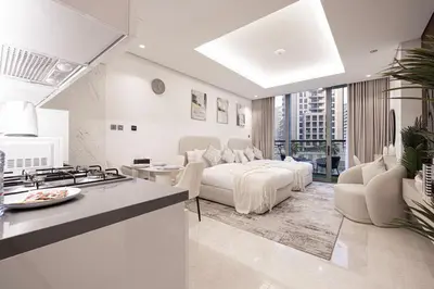 a kitchen and a living room with a bed and a stove at Luxurious New Studio! 2 Double Beds! Sleek Design & High-End Amenities in Dubai Downtown in Dubai
