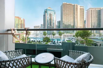 a balcony with chairs and a table and a view of a city at Luxurious New Studio! 2 Double Beds! Sleek Design & High-End Amenities in Dubai Downtown in Dubai