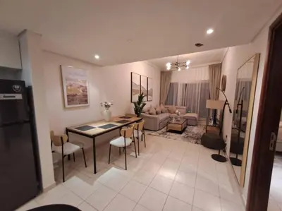 a kitchen and living room with a table and chairs at Spacious 1BR unit with Lake View in Dubai