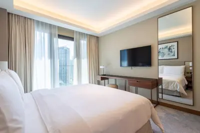 a hotel room with a bed and a large mirror at Luxury 2BR at Address Opera Downtown City View in Dubai