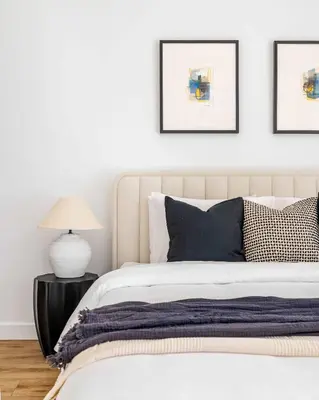 a bedroom with a white bed and three pictures on the wall at Silkhaus Chic 3BDR & maid room in Dubai Marina in Dubai