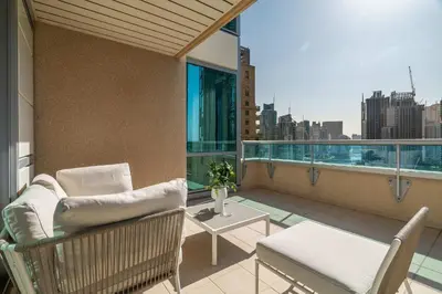 a balcony with a couch and a table on a building at Silkhaus Chic 3BDR & maid room in Dubai Marina in Dubai