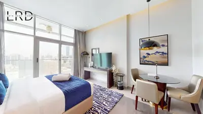 a bedroom with a bed and a desk and a table at Modern Studio in Majestine in Dubai