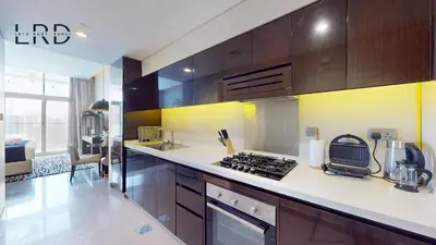a kitchen with wooden cabinets and a counter top at Modern Studio in Majestine in Dubai