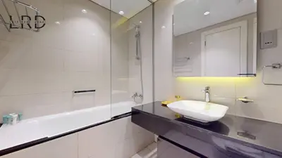 a white bathroom with a sink and a bath tub at Modern Studio in Majestine in Dubai