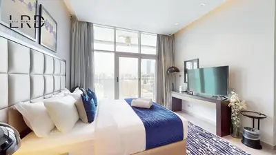 a hotel room with a bed and a television at Modern Studio in Majestine in Dubai
