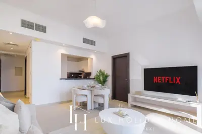 a living room with a tv and a table at LUX The Silverene Marina View Suite 4 in Dubai