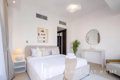 a white bedroom with a white bed and a mirror at LUX The Silverene Marina View Suite 4 in Dubai