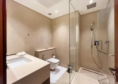 a bathroom with a shower and a toilet and a sink at Livbnb - 2BR Apartment with Breathtaking Marina View in Dubai