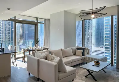 a living room with white furniture and large windows at Livbnb - 2BR Apartment with Breathtaking Marina View in Dubai