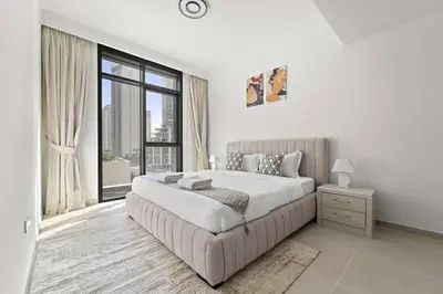 a white bedroom with a large bed and a large window at Luxury 1BR apartment at Creek Edge Tower 2 in Dubai