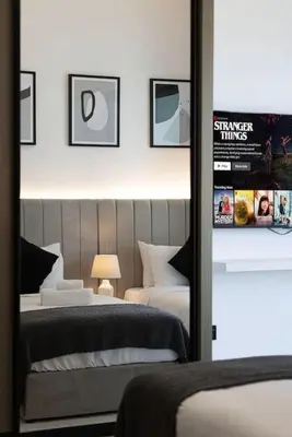 a bedroom with two beds and a mirror at Lux Apartment with huge private Lounge I Burj & Canal View in Dubai