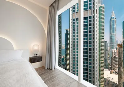 a bedroom with a large window with a view of the city at Jumeirah Living Marina Gate - Golf & Skyline Views with Pool & Gym in Dubai