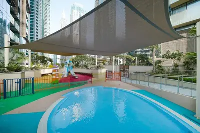 a swimming pool with a large umbrella on top of a building at Jumeirah Living Marina Gate - Golf & Skyline Views with Pool & Gym in Dubai