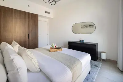 a bedroom with a large white bed and a mirror at Frank Porter - Lamtara 3 in Dubai