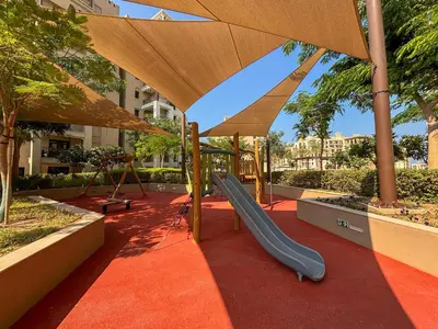 a playground with a slide and an umbrella at Frank Porter - Lamtara 3 in Dubai
