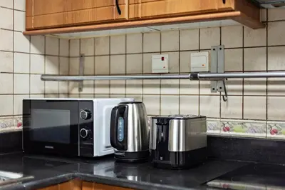 a kitchen counter with a microwave and a toaster at Cozy 1-Bedroom Apartment In Princess Tower in Dubai