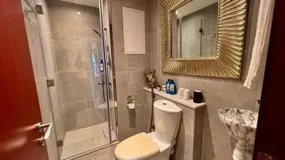 a bathroom with a shower and a toilet and a sink at JBR Marina View - 2BR Apartment in Dubai