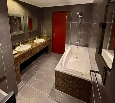 a bathroom with two sinks and a tub and a red door at JBR Marina View - 2BR Apartment in Dubai