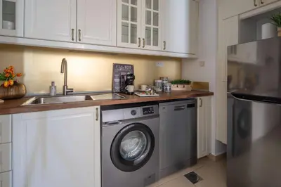 a kitchen with a washing machine and a sink at Frank Porter - Shams 4 in Dubai