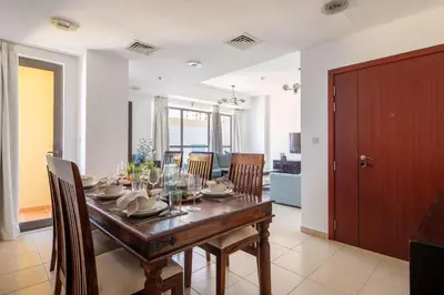 a dining room with a wooden table and chairs at Frank Porter - Shams 4 in Dubai