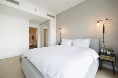 a bedroom with a large white bed and a lamp at Marina Views in Walkable Location with Pool & Gym in Dubai
