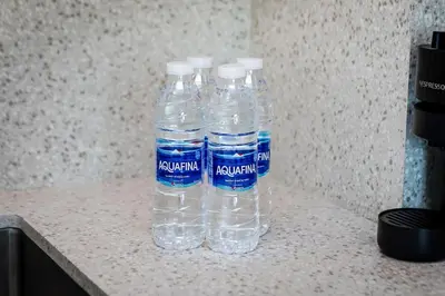 three bottles of water sitting on top of a counter at Marina Vista Private Beach 2BR in Dubai