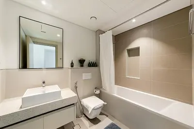 a bathroom with a sink and a toilet and a tub at Marina Vista Private Beach 2BR in Dubai