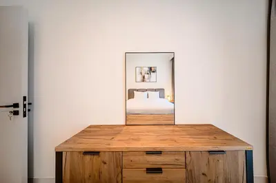a mirror on top of a wooden dresser in a bedroom at Stunning 1 bedroom sea view apartment in Dubai