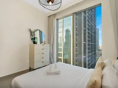 a bedroom with a white bed and a large window at Dream Location - Luxury and Comfort in Dubai in Dubai