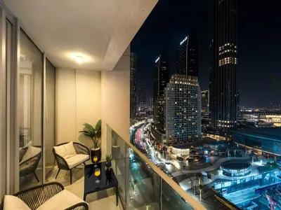 a balcony with a view of a city at night at Dream Location - Luxury and Comfort in Dubai in Dubai