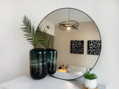 two black vases sitting on a table in front of a mirror at Dream Location - Luxury and Comfort in Dubai in Dubai