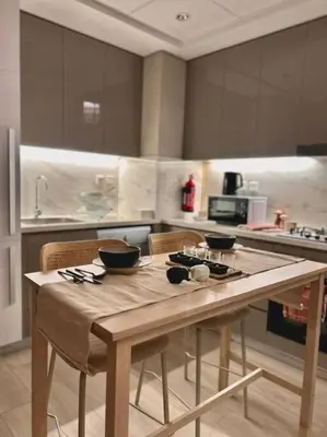 a kitchen with a wooden table with bowls on it at Cozy urban stay near Dubai Mall in Dubai