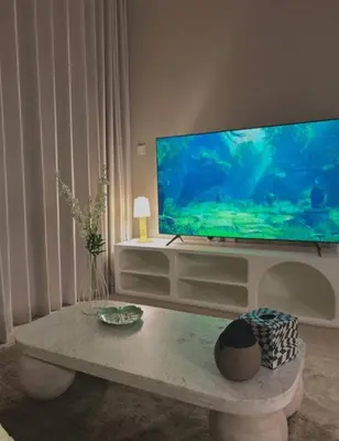 a living room with a large television and a table at Cozy urban stay near Dubai Mall in Dubai