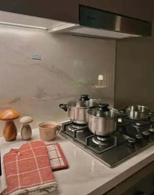 three pots on a stove top in a kitchen at Cozy urban stay near Dubai Mall in Dubai